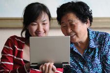 祖母和孙女看笔记本电脑